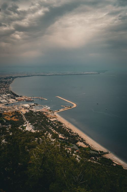 Free Aerial view of coastline under dramatic clouds, offering a moody seaside panorama. Stock Photo