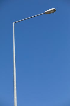A minimalistic view of a streetlamp against a clear blue sky shot from a low angle.