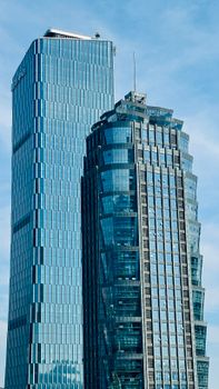 Twin tower skyscrapers against blue sky in Chongqing, showcasing modern architectural design.
