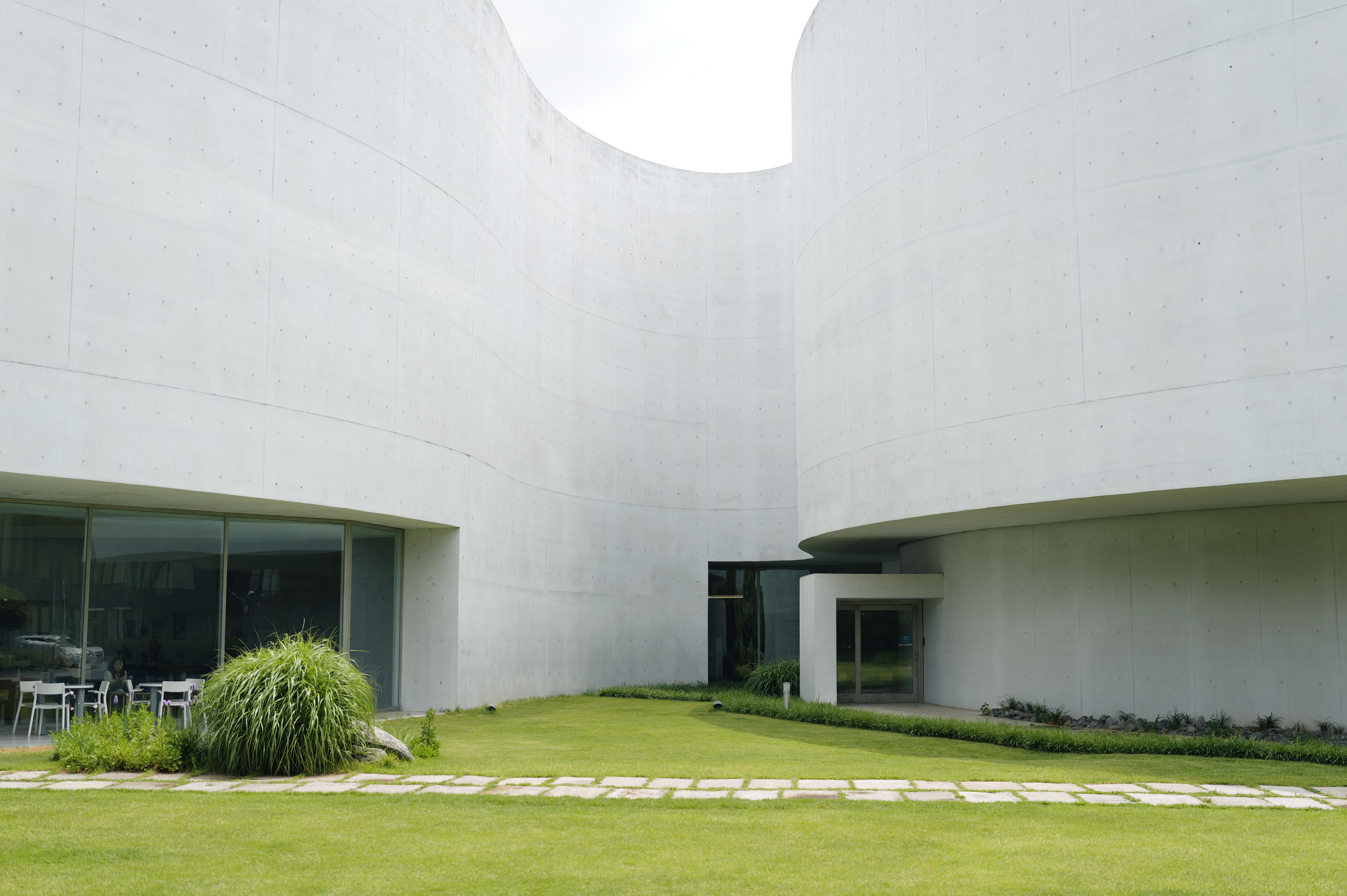 A sophisticated minimalist view of a modern architectural structure with clean lines and reflective glass.