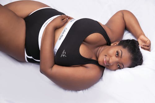 бесплатная Пухлая черная женщина, расслабляющаяся на кровати по утрам Стоковое фото