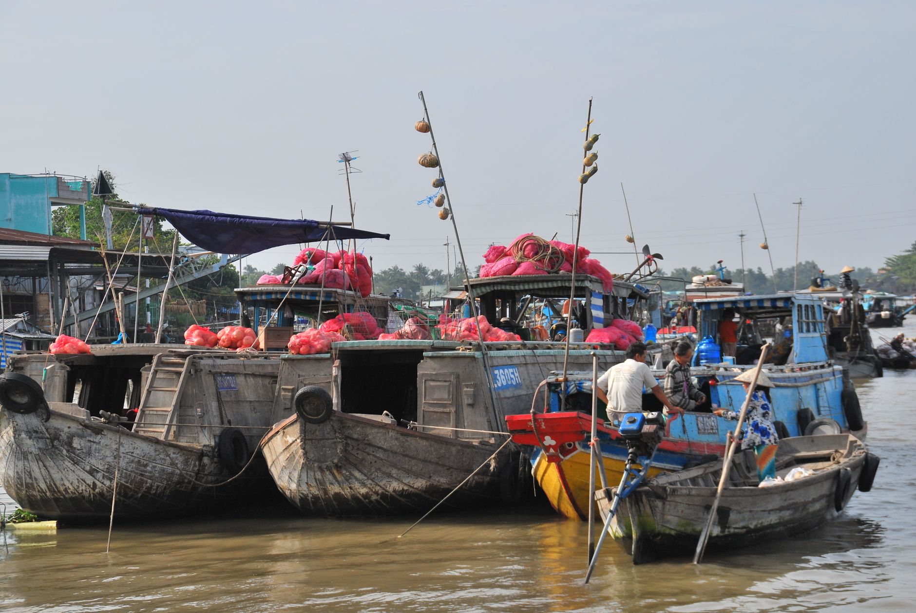 Vibrant scene of boats at a Mekong Delta floating market, featuring colorful goods and lively activity. — photo by Micha Höfer / Pexels