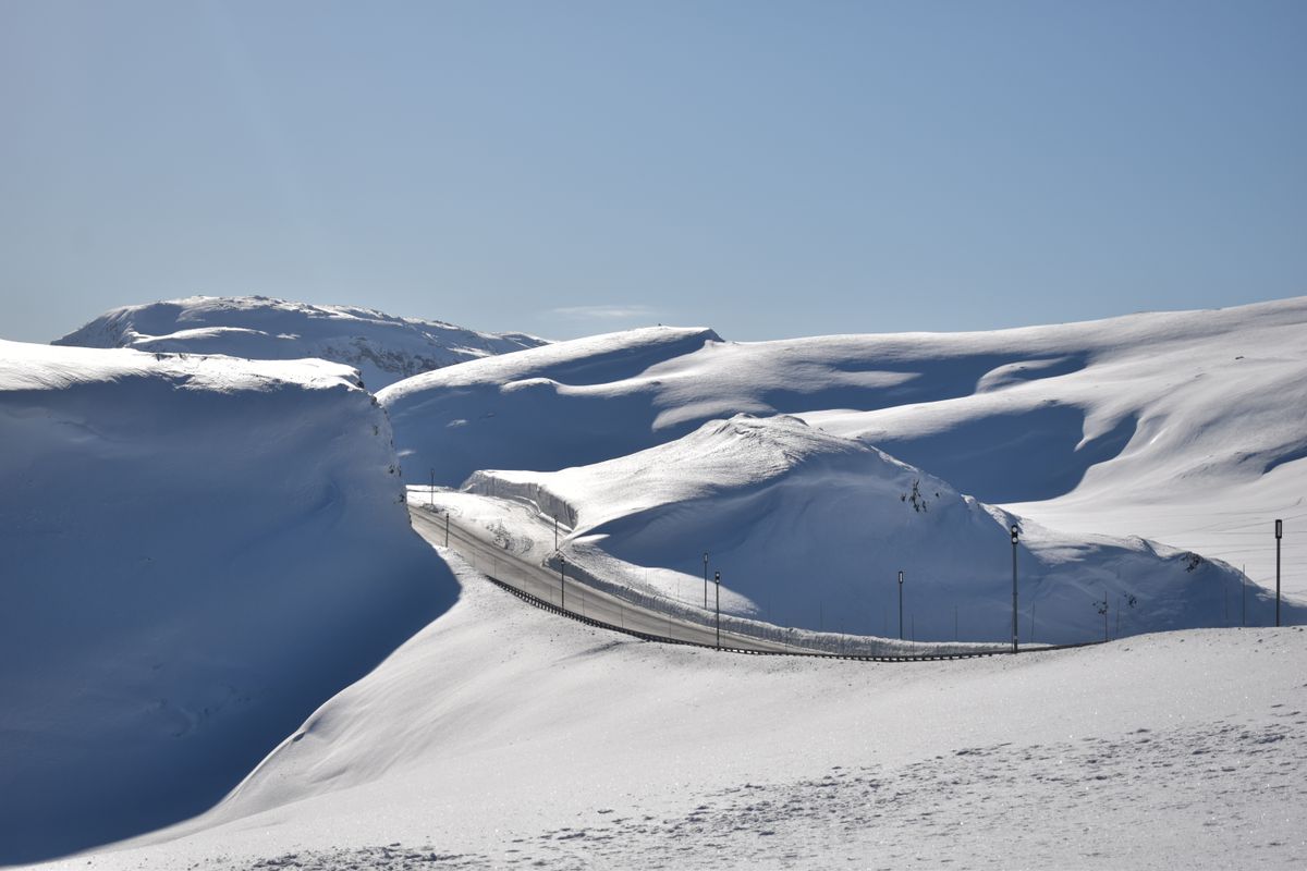 Drum serpuit printre munti innevati in Norvegia