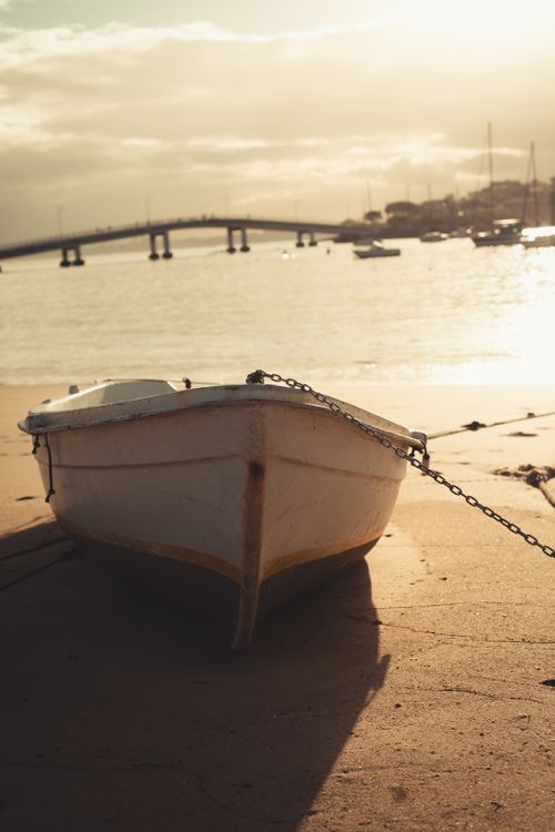 Free A serene beach scene with a boat at sunrise in Espírito Santo, Brasil. Ideal for travel and nature themes. Stock Photo