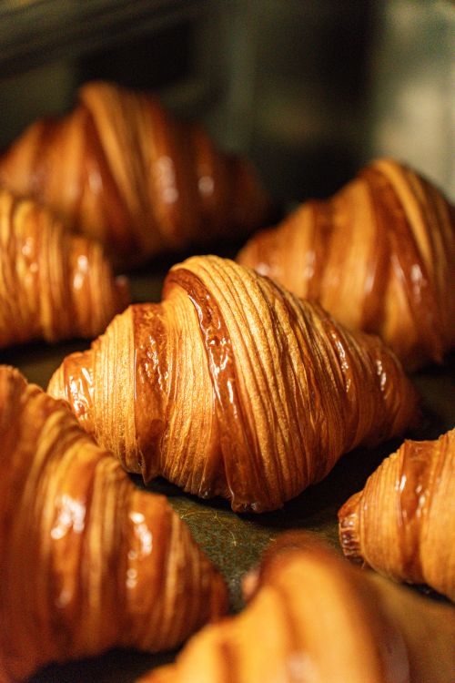 Free Golden, flaky croissants cooling on a baking tray, perfect for breakfast or brunch settings. Stock Photo