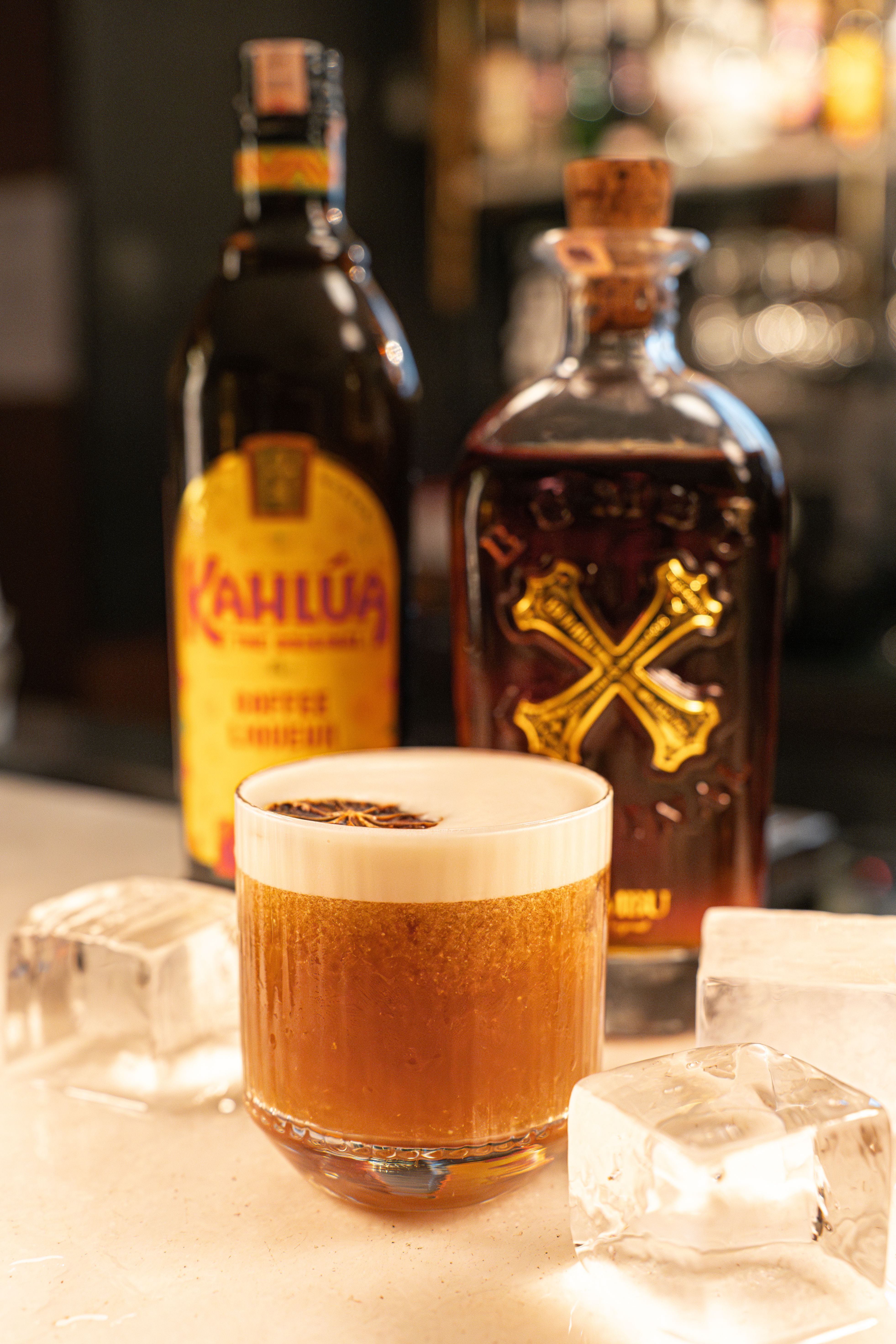 A delicious alcoholic cocktail featuring Kahlua and cognac, served with ice on a bar counter.