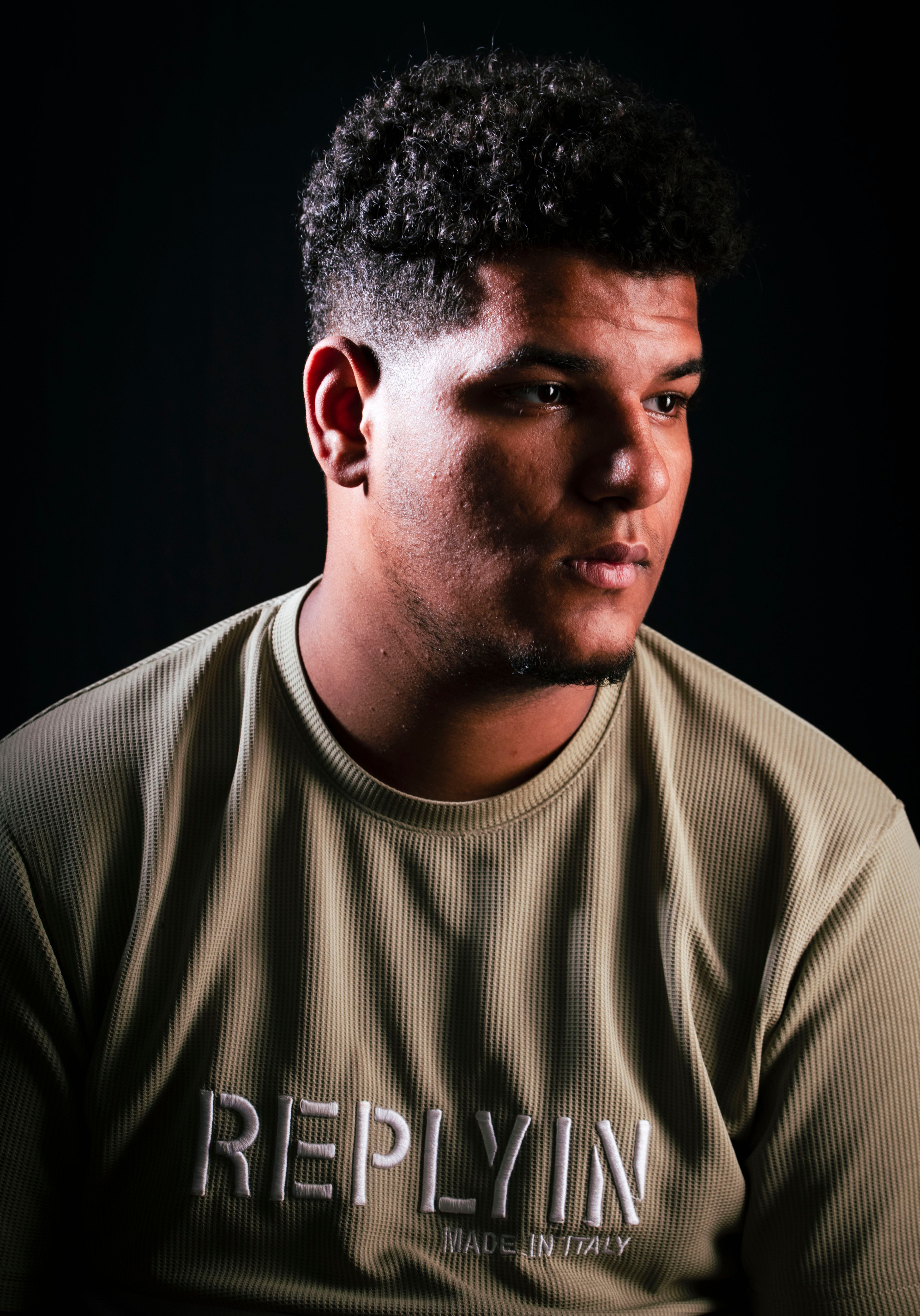 Close-up portrait of a young man in thoughtful expression, soft lighting.