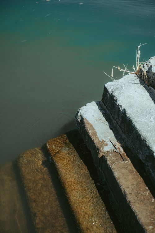 Free Serene stone steps descending into tranquil turquoise water, capturing a peaceful scenery. Stock Photo