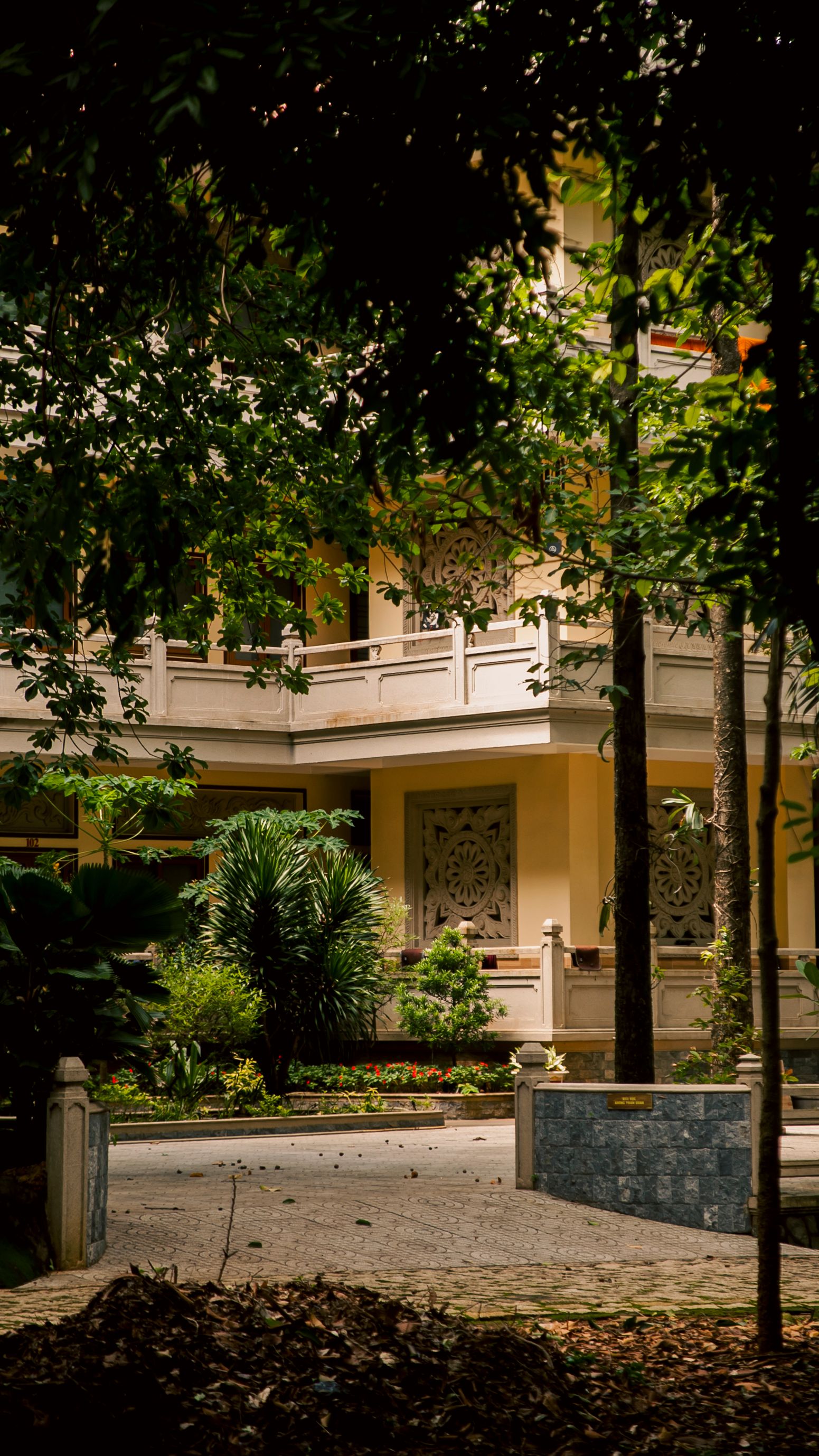 Charming courtyard surrounded by greenery and traditional architecture in Hồ Chí Minh City, Vietnam.