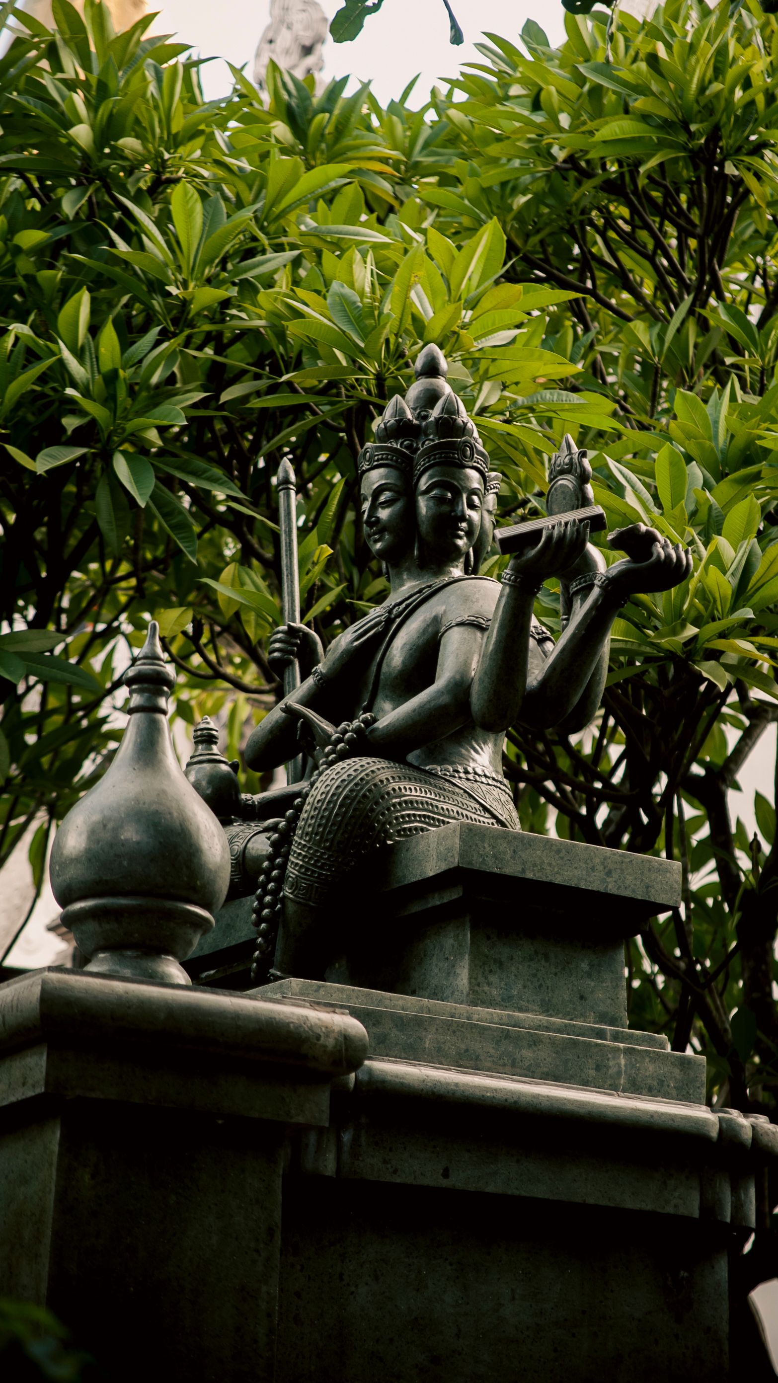 A detailed sculpture set amid lush greenery in a Ho Chi Minh City garden, Vietnam.