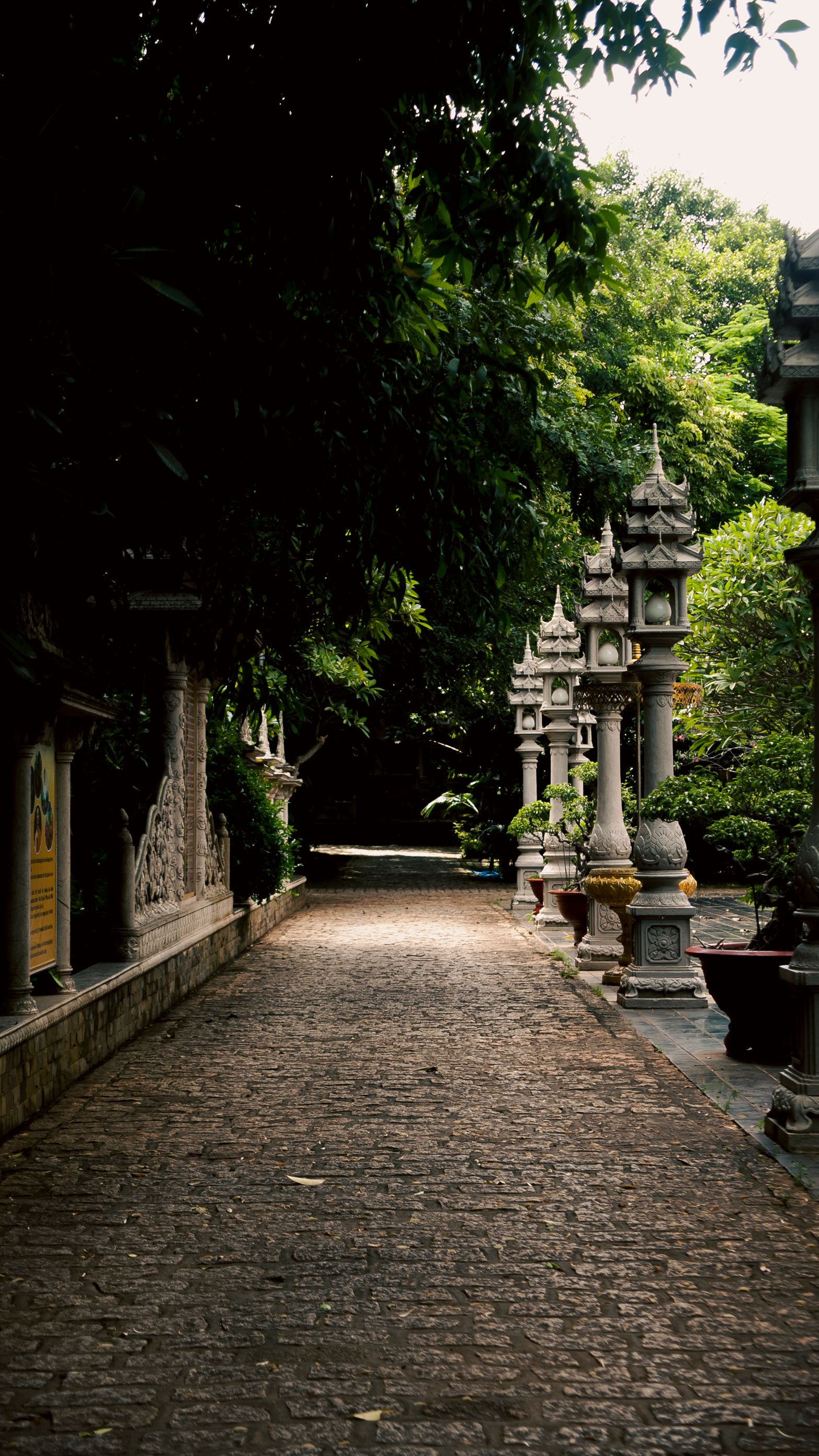 Peaceful stone path lined with traditional lanterns in a lush garden, Ho Chi Minh City.