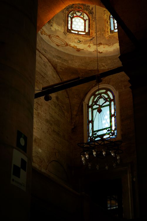 Free Historic church interior featuring beautiful stained glass and chandelier lighting. Stock Photo