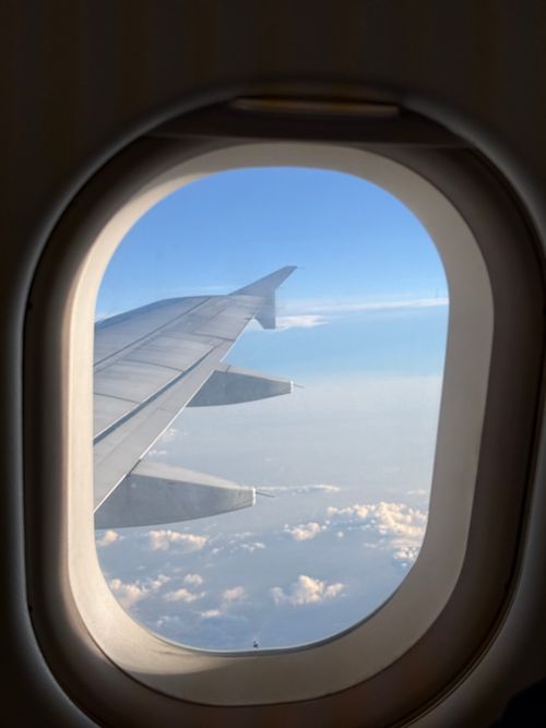 Free Serene view of clouds and sky from an airplane window, capturing the wing and vast horizon. Stock Photo