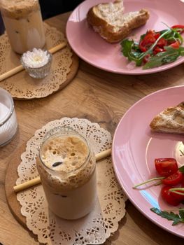 Enjoy a relaxing brunch with iced coffee, fresh salad, and toast. Perfect meal for a cozy day.