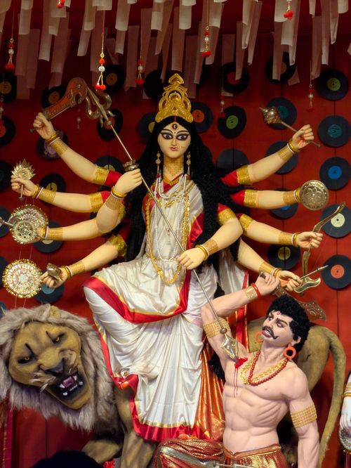 Free Vibrant idol of goddess Durga with multiple arms, lion, and demon figure, representing Hindu mythology. Stock Photo