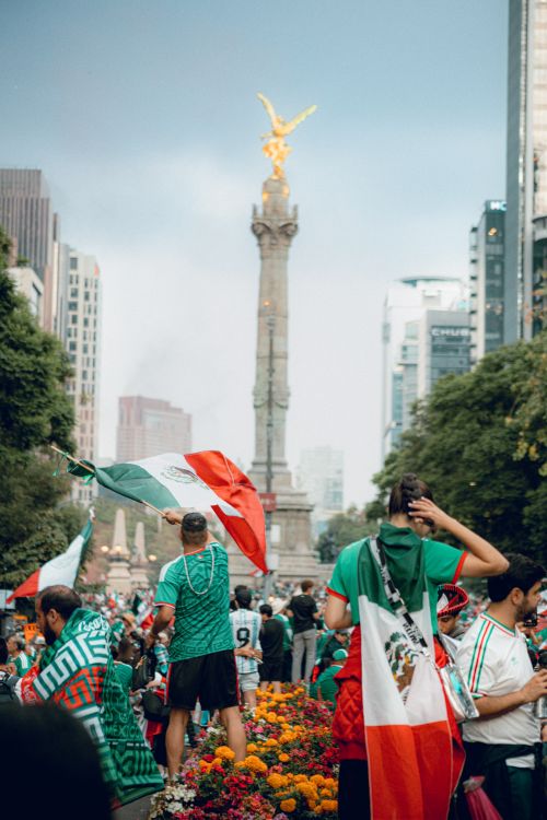 Free A vibrant crowd celebrates at the Angel of Independence in Mexico City with Mexican flags. Stock Photo
