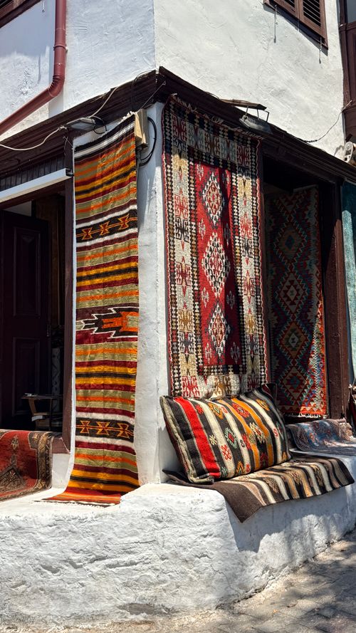 Free Colorful traditional Turkish carpets and textiles hang on a wall in a sunlit street in Antalya, Turkey. Stock Photo