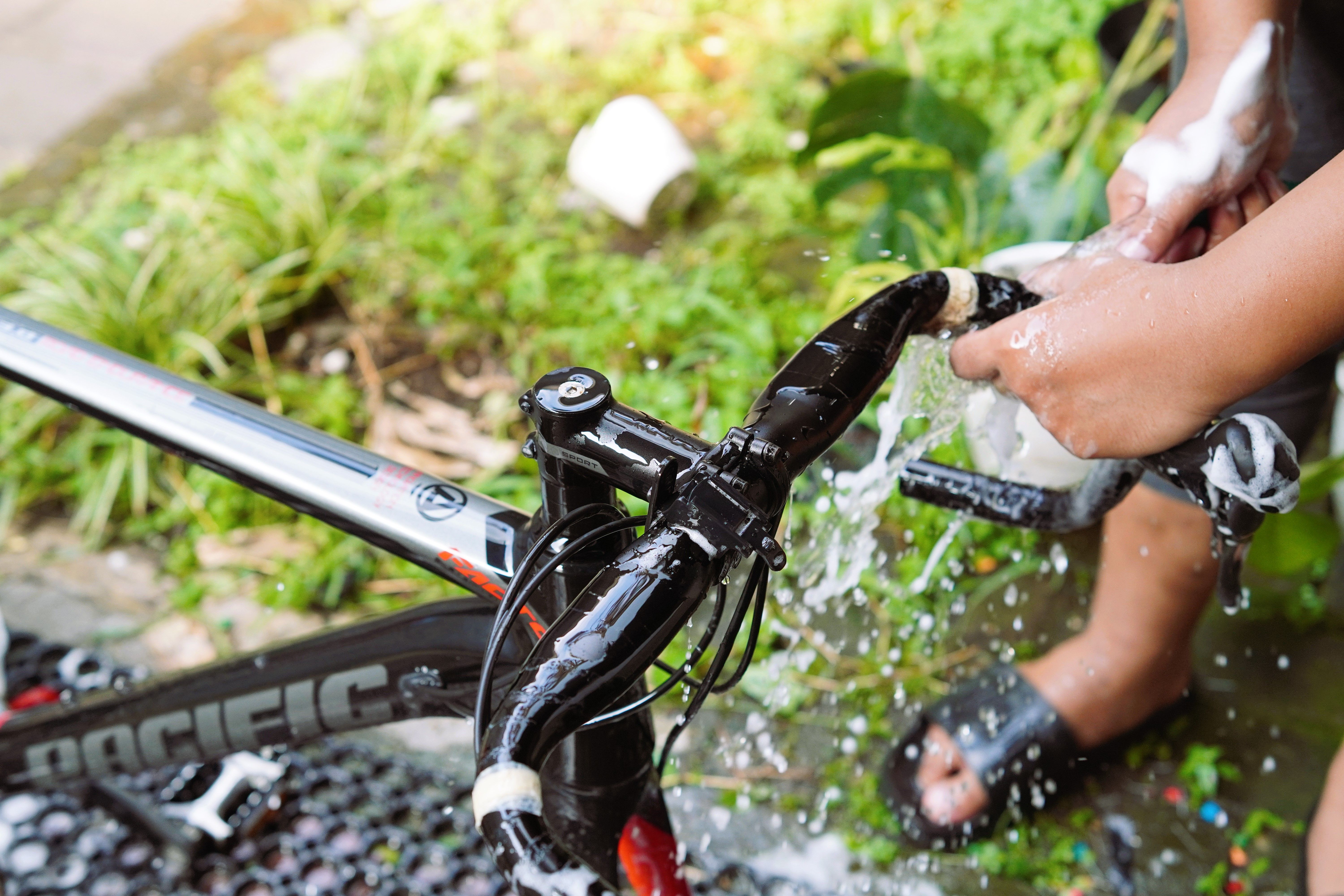 person rinsing a small water pump filter in a garden sink