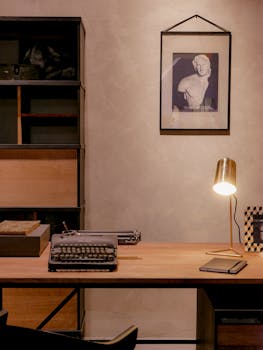 A warm vintage home office setup featuring a typewriter on a wooden desk with cozy lighting.