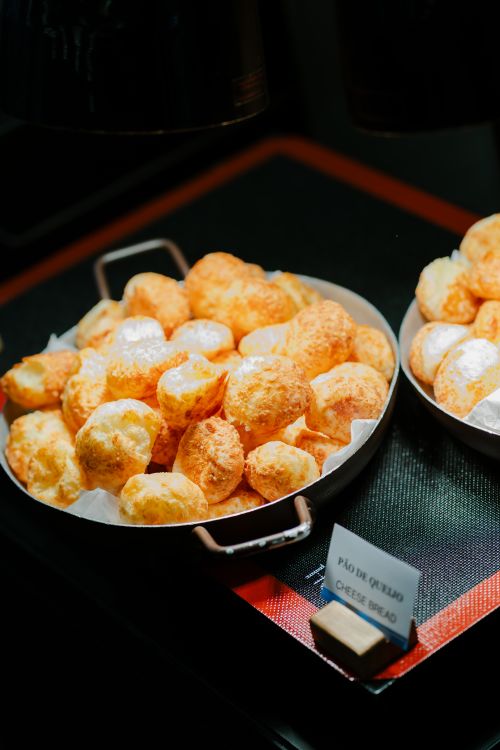 Free Authentic Brazilian cheese bread (Pão de Queijo) served fresh in a restaurant setting. Stock Photo