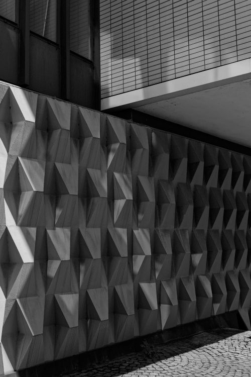 Free Black and white photo of a geometric architectural facade with striking patterns. Stock Photo