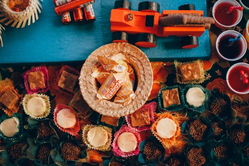 Free Top view composition of various sweets placed on table near disposable  cups of sweet drinks and candies served in wicker basket and toy car placed on top Stock Photo
