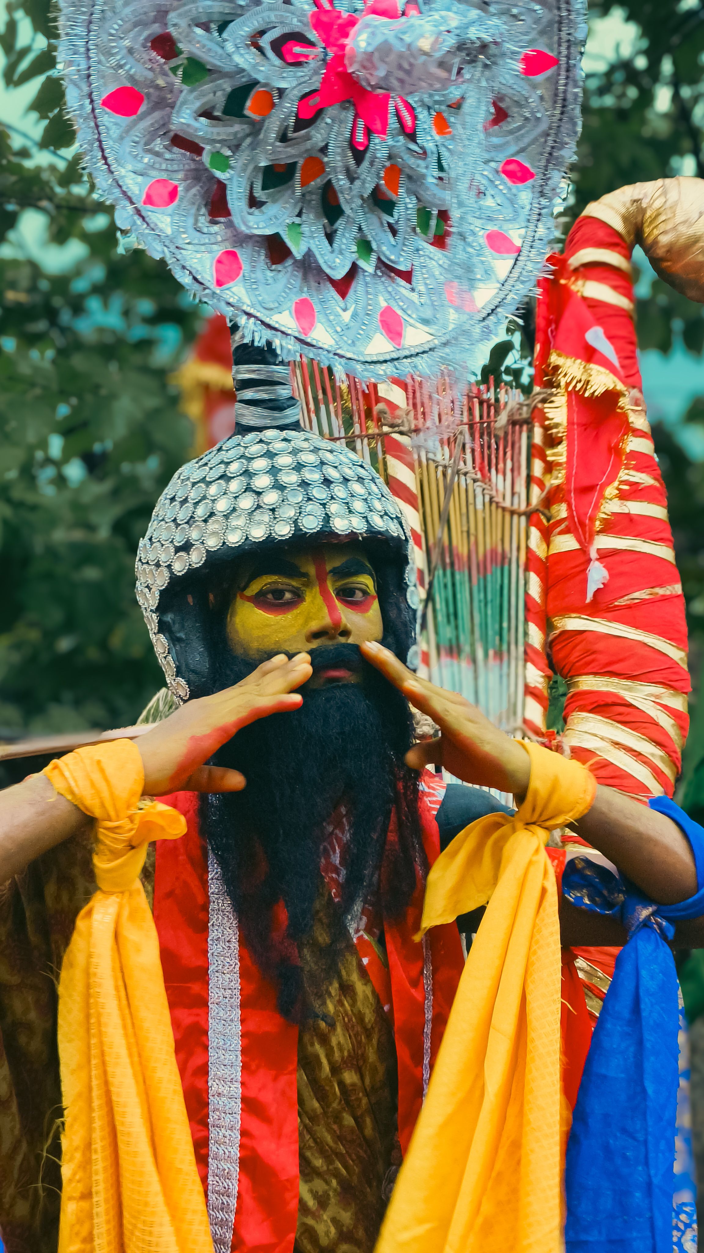 Colorful portrait of a traditional Indian festival performer in elaborate costume and face paint.