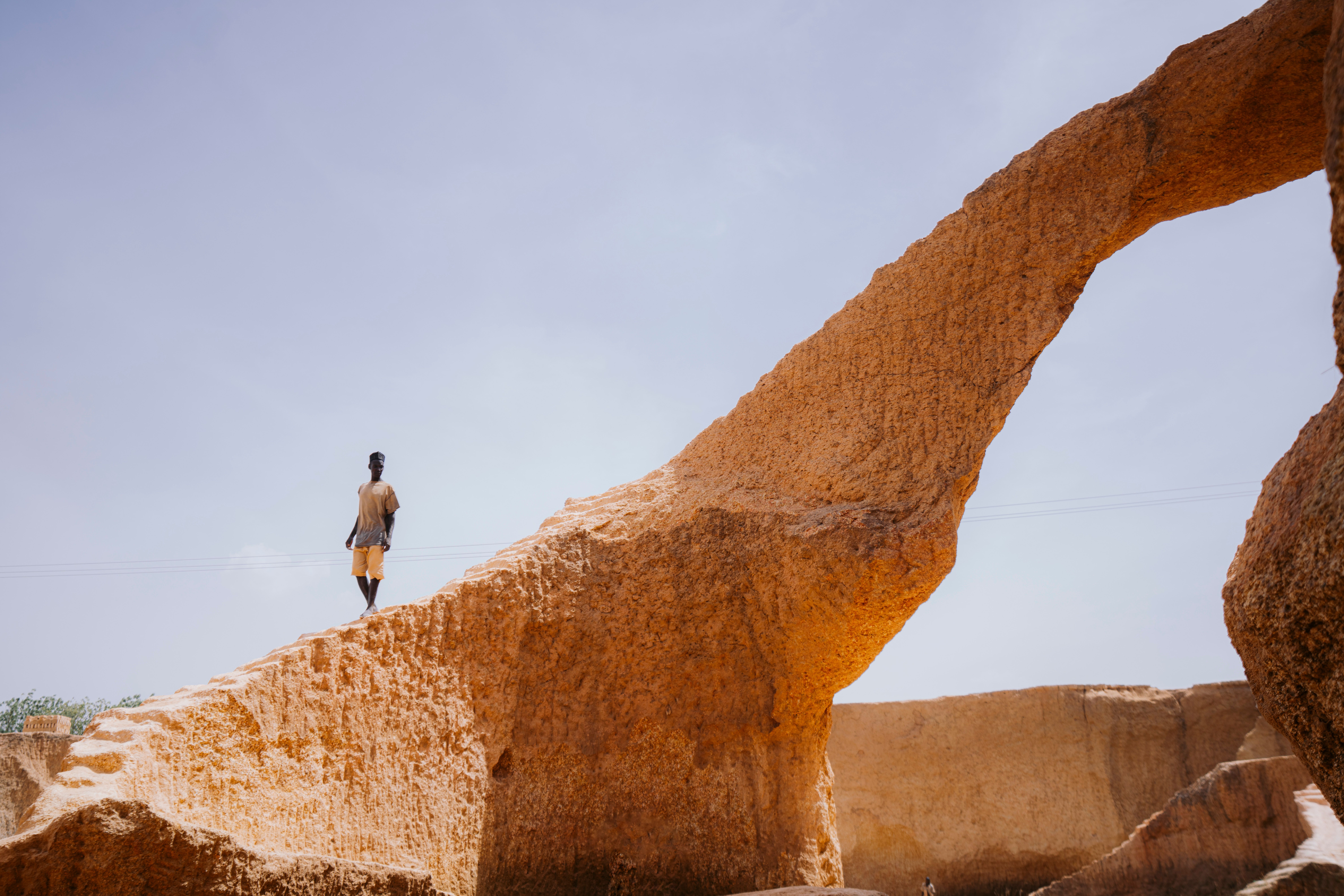 Man exploring natural arch formation in desert, Chad