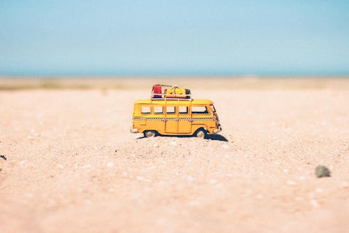 Free Yellow Die-cast Miniature Van on Brown Sand Stock Photo