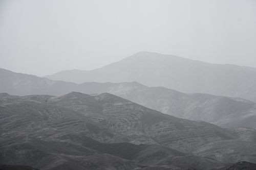 Free Monochrome view of fog-kissed mountains creating a serene, misty layered landscape. Stock Photo