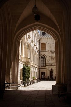 Captivating view through a medieval archway into a sunlit Czech courtyard.