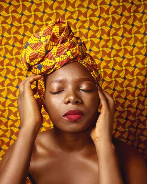 Free Striking portrait of a woman wearing a colorful African patterned headwrap, showcasing cultural elegance. Stock Photo