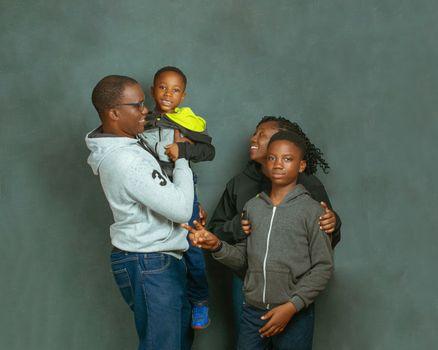 A joyful African family of four posing together in casual clothing, enjoying a moment of togetherness.