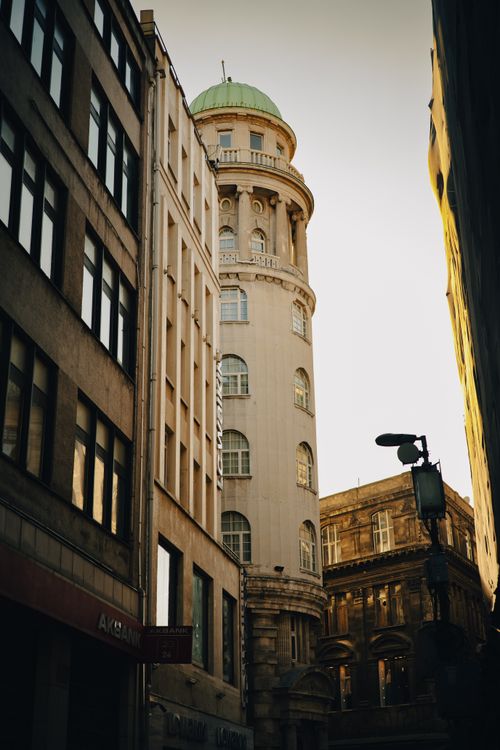 Free Sunlit historic tower in a narrow European city alley, showcasing vintage architecture. Stock Photo