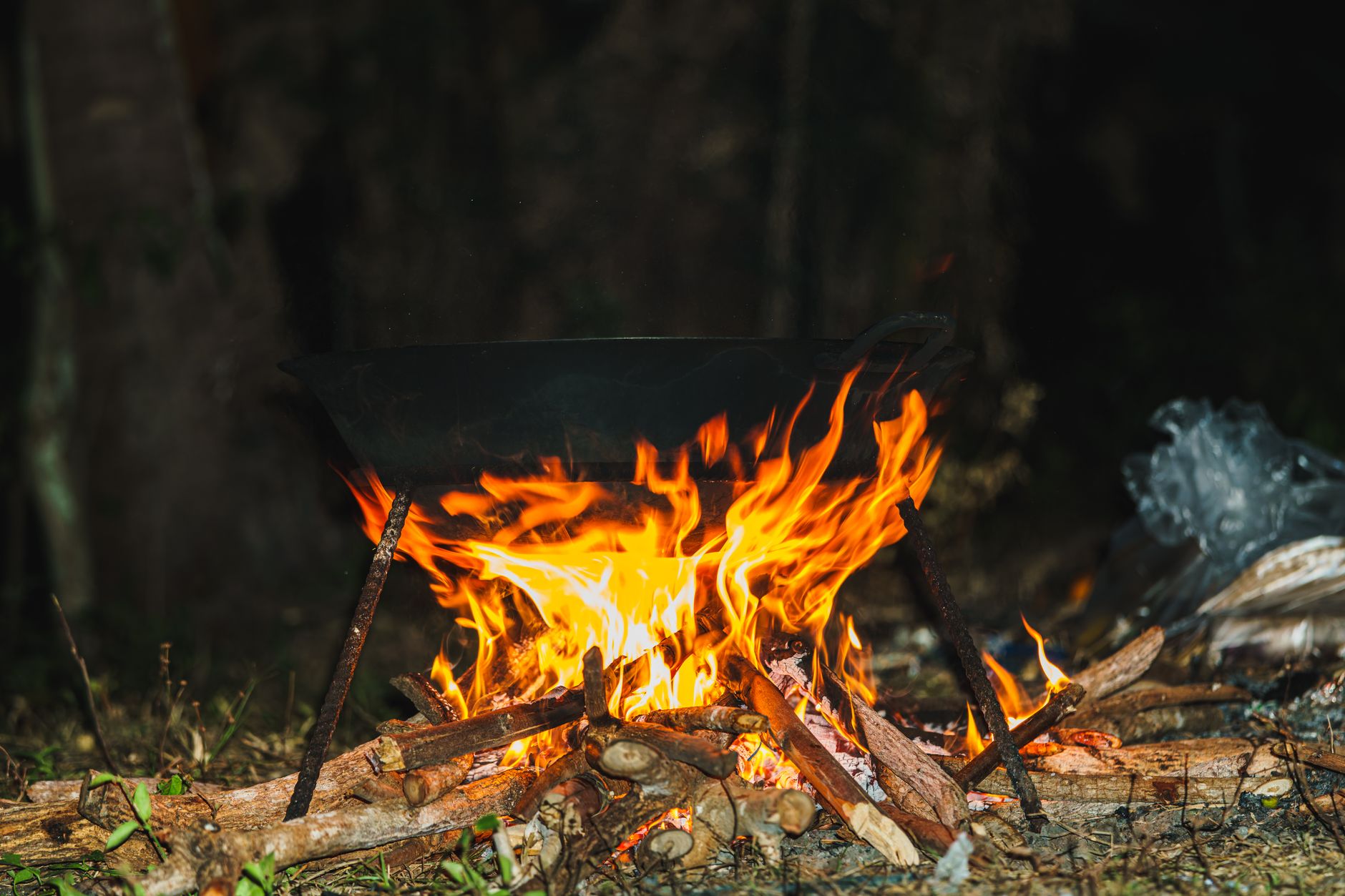Frigideira de ferro fundido sobre a chama baixa do fogão, com cebolas dourando lentamente, numa cozinha iluminada por luz quente