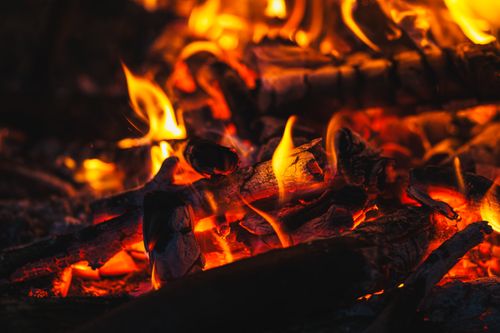Free A vivid and warm close-up of burning firewood with glowing embers and flickering flames. Stock Photo