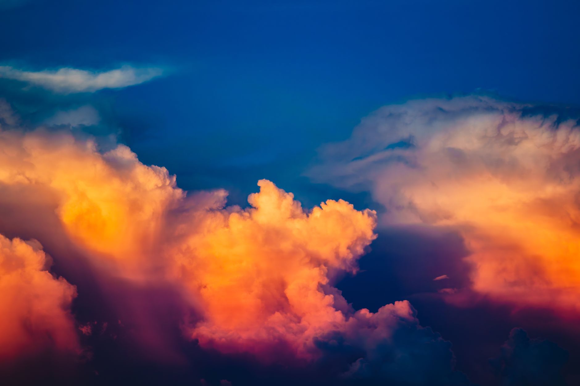 Vibrant clouds illuminated by a stunning sunset, showcasing vivid hues in a calm sky.