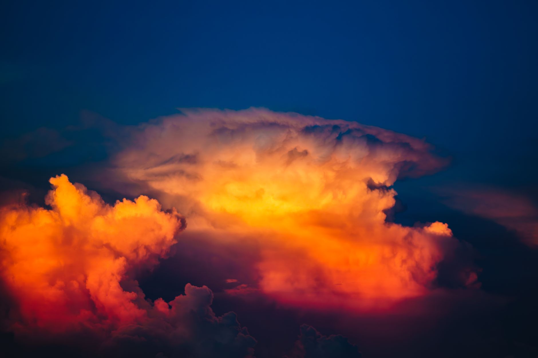 A vivid cumulus cloud glowing with warm colors during a stunning sunset.