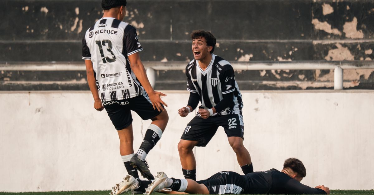 Football players in black and white jerseys celebrate a goal on the field.