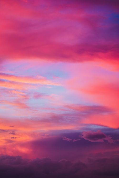 Free A stunning view of a vibrant sunset sky filled with pink and purple clouds creating a dramatic scene. Stock Photo