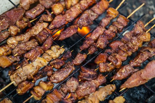 Free Close-up of assorted meat skewers grilling over open fire, showcasing juicy textures and rich flavors. Stock Photo
