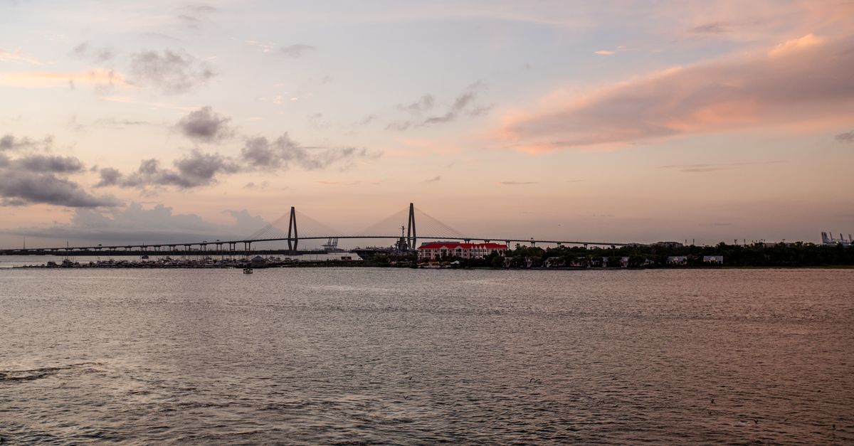 Stunning view of the bridge and skyline at sunset with colorful skies over the water.