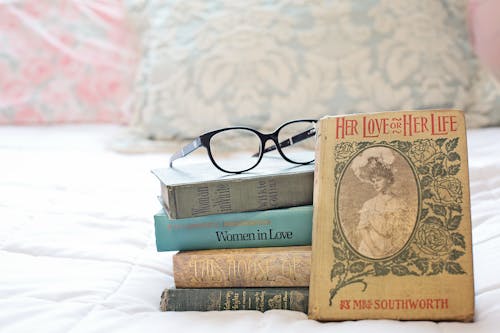 A Stack of Vintage Books on the Bed