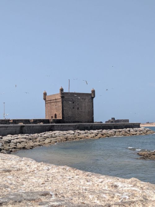 Free Historic fortified tower in Essaouira, Morocco with coastal surroundings and seagulls. Stock Photo