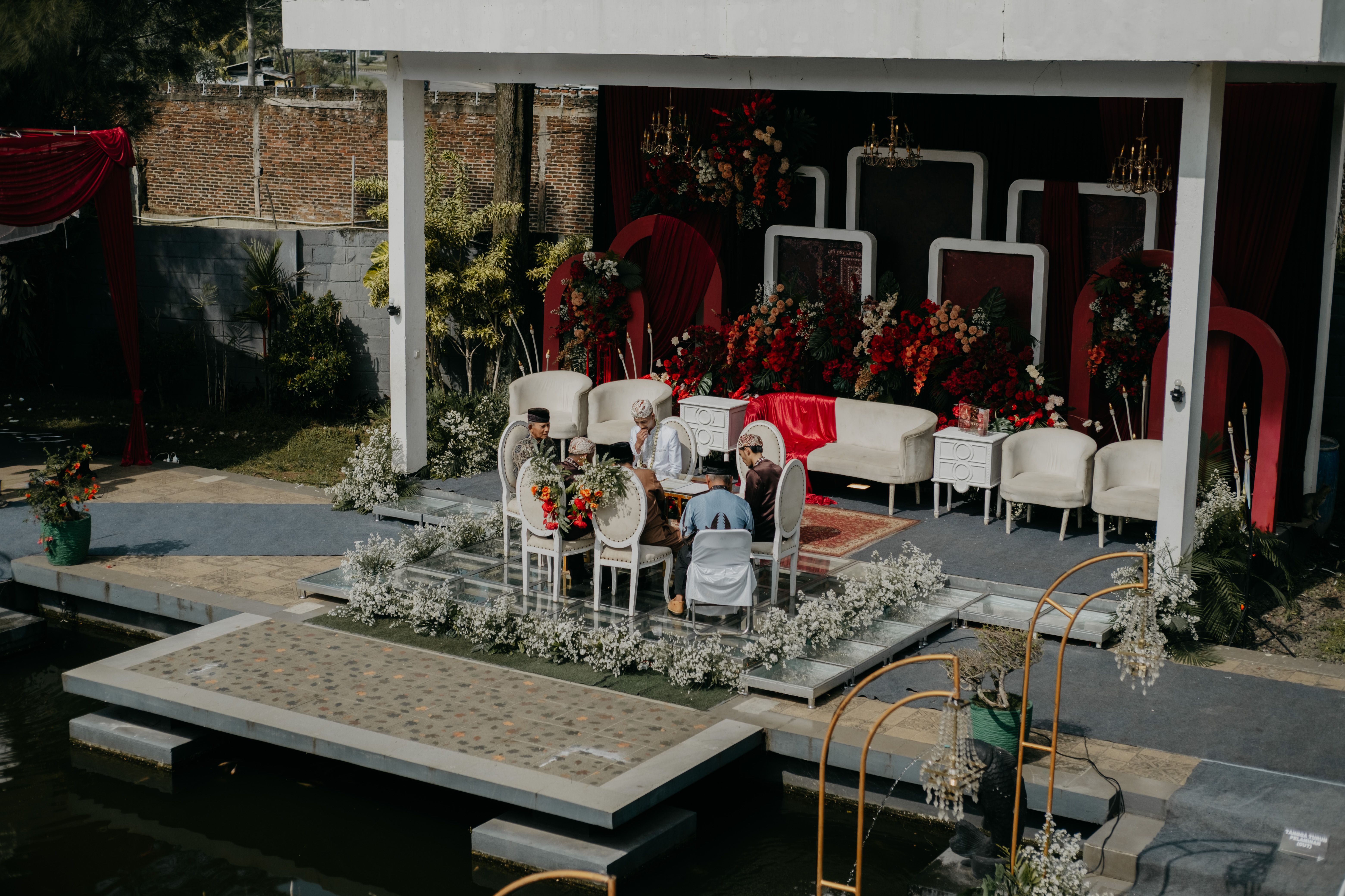 Elegant outdoor wedding ceremony setup with floral decorations and ornate chairs.