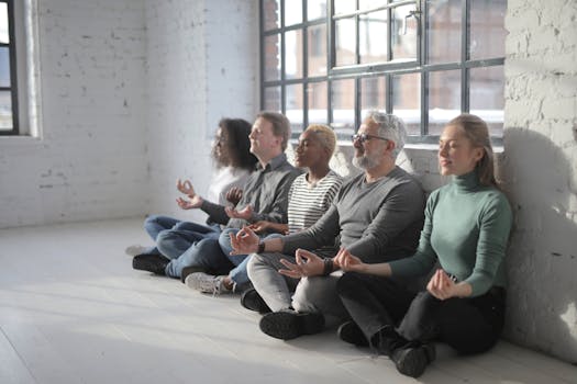 A diverse team meditates together in a peaceful office space.