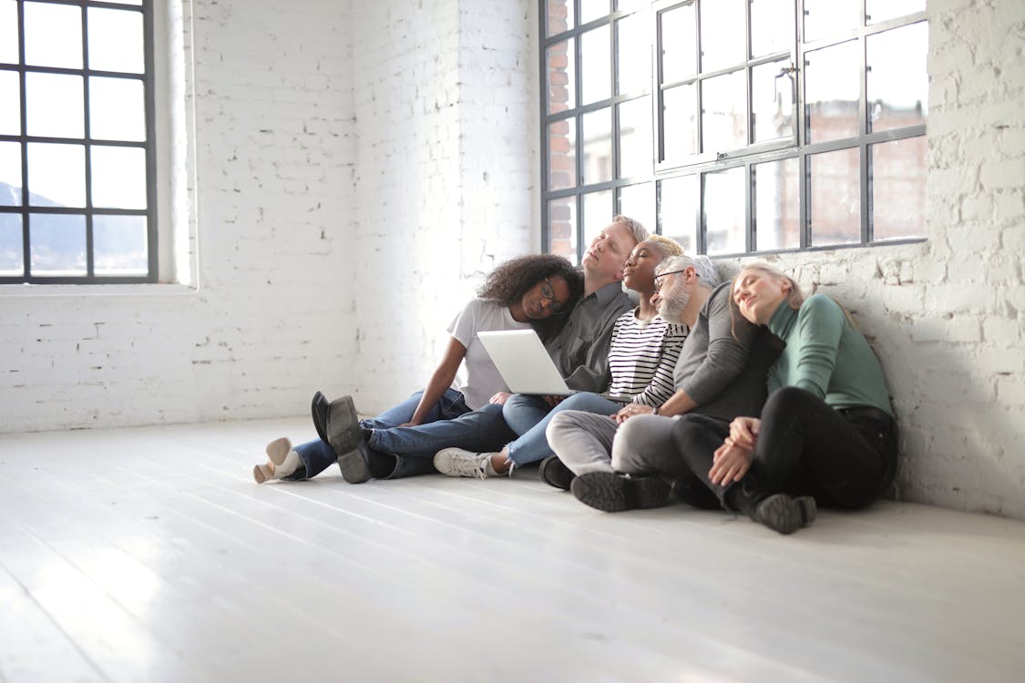 People Sitting On The Floor Feeling Exhausted