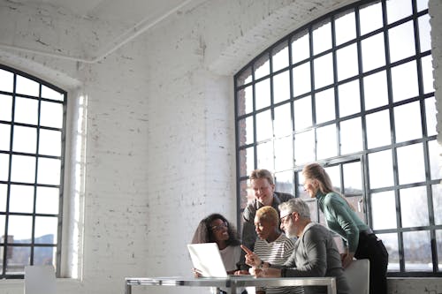 Free Group of coworkers discussing project in modern workplace Stock Photo