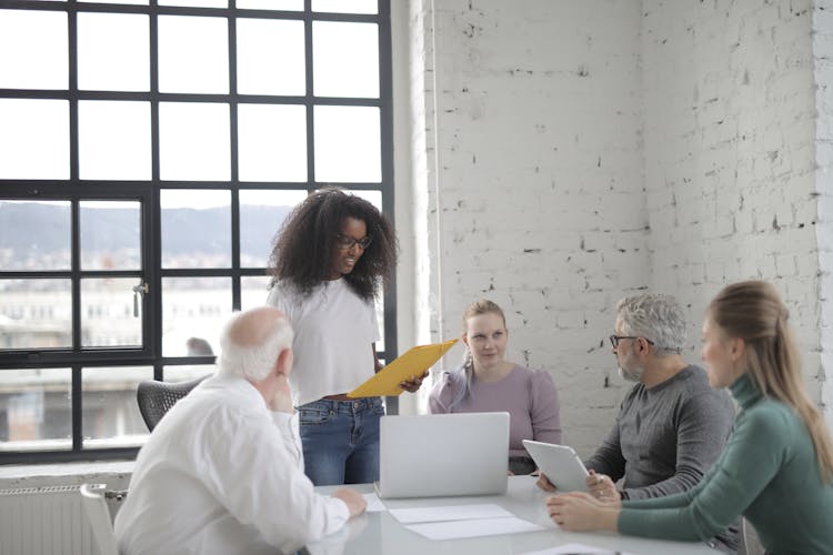 Smiling Woman Explaining Project To Colleague