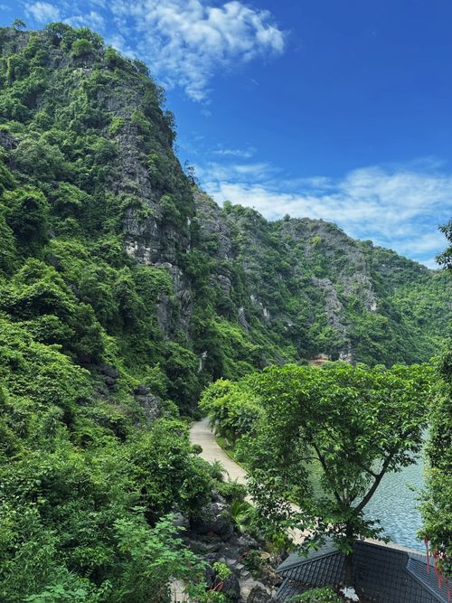 Free Lush green limestone cliffs overlooking a tranquil river on a sunny day. Stock Photo